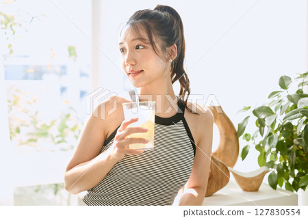 夏日清爽的年輕女子在房間裡喝檸檬水 127830554