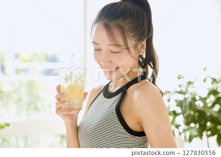 Summer refreshing young woman drinking lemonade in room Summer refreshing young woman drinking lemonade in room 127830556
