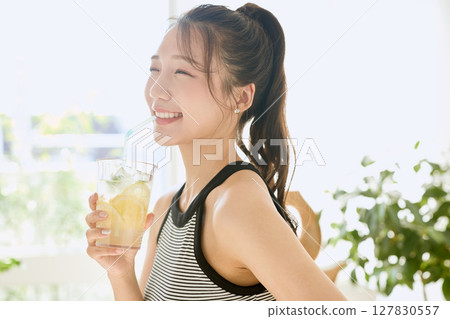 Summer refreshing young woman drinking lemonade in room Summer refreshing young woman drinking lemonade in room 127830557