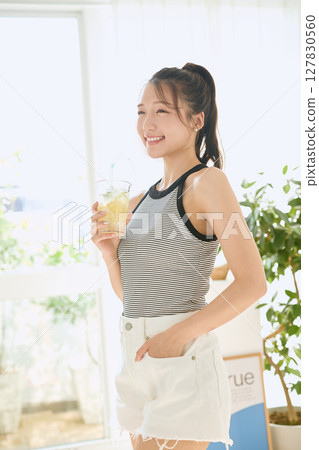 Summer refreshing young woman drinking lemonade in room 127830560