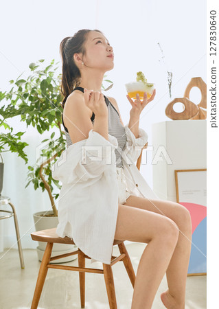 一位微笑的年輕女子吃刨冰享受夏日的生活方式 127830640