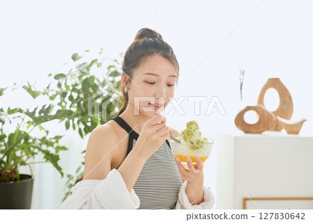 Lifestyle of a smiling young woman eating shaved ice and enjoying summer Lifestyle of a smiling young woman eating shaved ice and enjoying summer 127830642