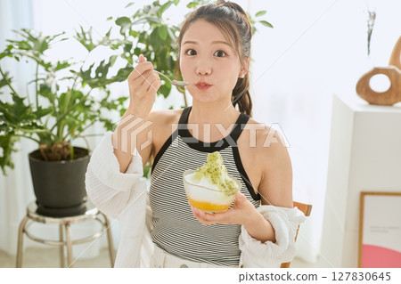 Lifestyle of a smiling young woman eating shaved ice and enjoying summer 127830645