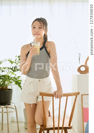 Summer refreshing young woman drinking lemonade in room 127830650