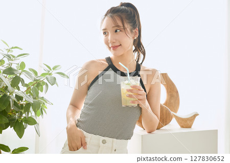 Summer refreshing young woman drinking lemonade in room 127830652