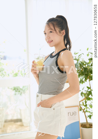 Summer refreshing young woman drinking lemonade in room 127830658