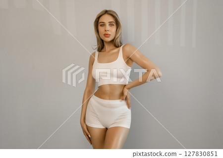 Perfect shape of belly, hips. Beautiful body of young slim woman in white underwear isolated on gray studio background. Wellness, weight loss, treatment, healthcare, fitness concept. Flyer 127830851