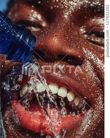 Refreshing Burst Hydration in Action A Close Up of a Man Face as Cool Water Splashes Over Him from a Vibrant Blue Bottle, Capturing the Essence of Thirst Quenching and Revitalization 127831203