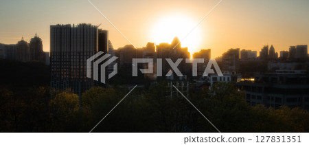 City Skyline at Sunset with Golden Sunlight Silhouette 127831351
