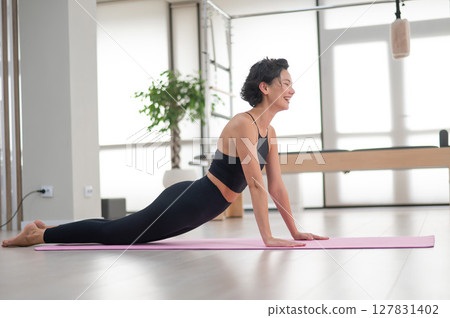 Asian woman doing upward facing dog exercise. Yoga class. Asian woman doing upward facing dog exercise. Yoga class. 127831402