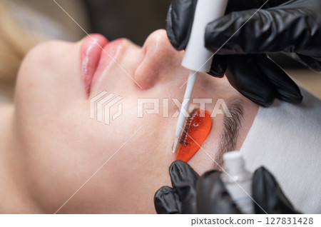 Caucasian woman undergoing eyelash lamination procedure. Caucasian woman undergoing eyelash lamination procedure. 127831428