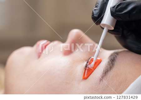 Caucasian woman undergoing eyelash lamination procedure.  127831429
