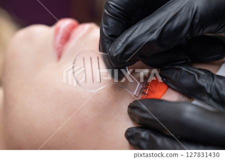 Caucasian woman undergoing eyelash lamination procedure.  127831430