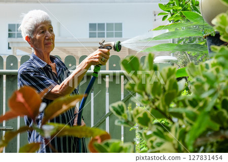 Senior asian woman watering the garden 127831454