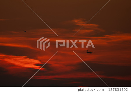 Airplane flying in the sunset sky 127831592