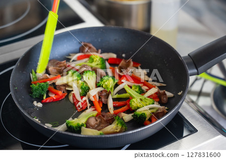 Beef and vegetables are fried in a frying pan. Beef and vegetables are fried in a frying pan. 127831600