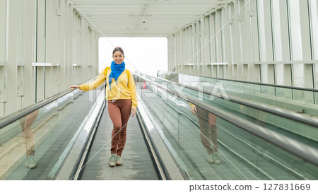 Portrait of a woman moving on a travolator Portrait of a woman moving on a travolator 127831669