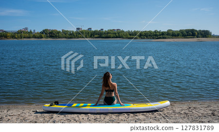 Caucasian woman posing on a SUP board. Summer sport. 127831789