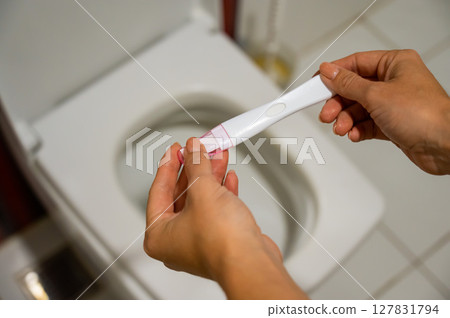 A woman takes an express pregnancy test. A woman takes an express pregnancy test. 127831794