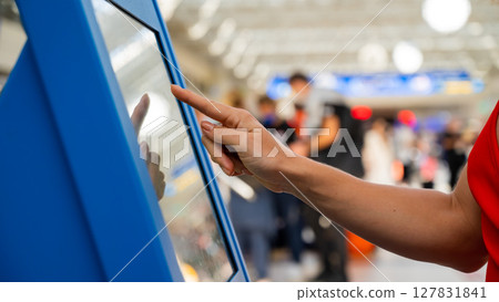 Interacting with a touchscreen kiosk at an airport.  127831841