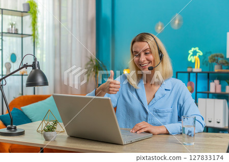 Businesswoman wearing headset support service operator helpline call center talking with client Businesswoman wearing headset support service operator helpline call center talking with client 127833174