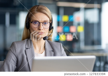 Portrait of serious confident woman with headset. Close-up businesswoman in business suit looking at camera, online bank and insurance company support service worker. 127833394