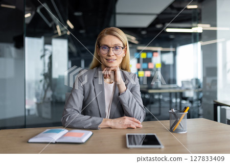 Shot of a confident businesswoman in a blazer looking directly into the camera with a gentle smile during a video conference 127833409
