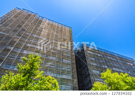 Yokohama cityscape in Japan. Apartment building repairs and inspections, scaffolding and protective nets. Satellite antennas outside the nets... Yokohama cityscape in Japan. Apartment building repairs and inspections, scaffolding and protective nets. Satellite antennas outside the nets... 127834102