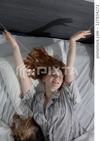 Woman Enjoying a Lazy Morning in Bed With a Cozy Atmosphere and Pet Dog Nearby Woman Enjoying a Lazy Morning in Bed With a Cozy Atmosphere and Pet Dog Nearby 127834272
