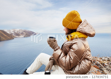 A young girl is a traveler at a rest stop. Admiring the beautiful winter landscape 127834731