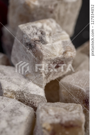Turkish delight with cherry on a slate close up, cubes of sweet Turkish delight with the addition of dried red berries in powdered sugar Turkish delight with cherry on a slate close up, cubes of sweet Turkish delight with the addition of dried red berries in powdered sugar 127834852