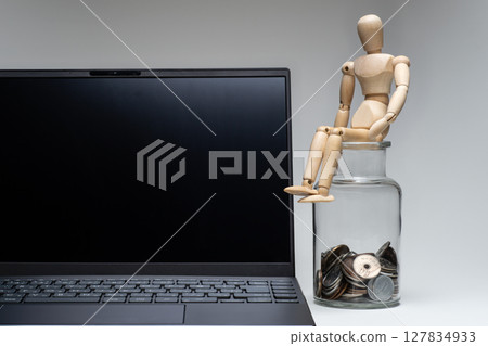 一個正在思考電腦和金錢的繪畫娃娃 一個正在思考電腦和金錢的繪畫娃娃 127834933