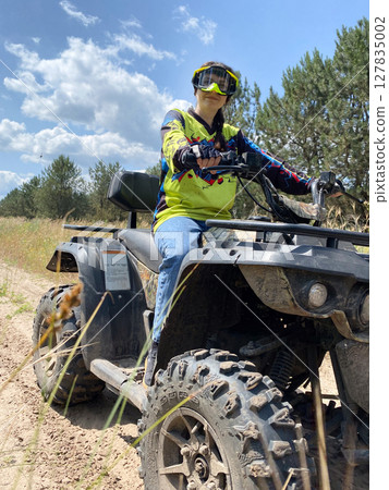 Quad bike ride on dirt roads in nature, vertical shooting Quad bike ride on dirt roads in nature, vertical shooting 127835002