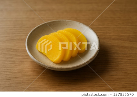 Yellow takuan paste served on a small plate 127835570
