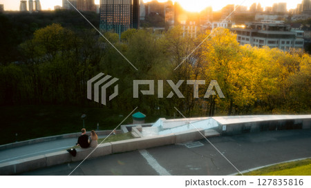 Couple Walking Through Urban Park at Sunset in Ukraine Couple Walking Through Urban Park at Sunset in Ukraine 127835816