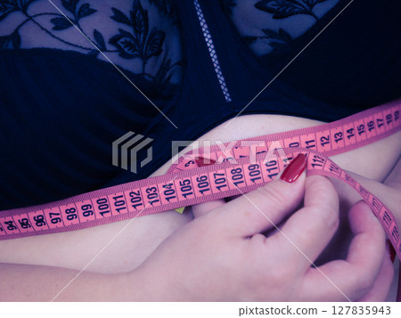 Woman measuring her chest under breasts Woman measuring her chest under breasts 127835943