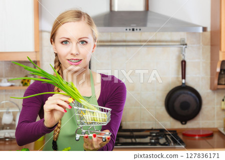 Woman holding shopping cart with chive inside 127836171