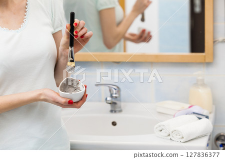 Female hand holding clay mud mask and brush. Skin care. Female hand holding clay mud mask and brush. Skin care. 127836377