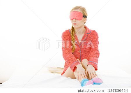 Sleepy woman wearing pink eye band Sleepy woman wearing pink eye band 127836434