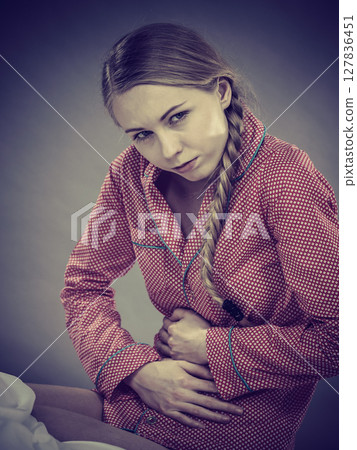 Sad young teenager woman on bed feeling pain 127836451