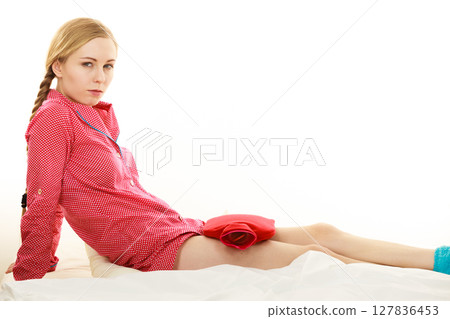 Young woman lying on bed wearing pajamas 127836453