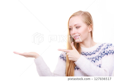 Teenage blonde woman pointing at copyspace Teenage blonde woman pointing at copyspace 127836517