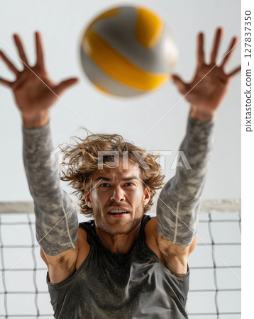 Dynamic non-binary athlete executes impressive block during volleyball match 127837350