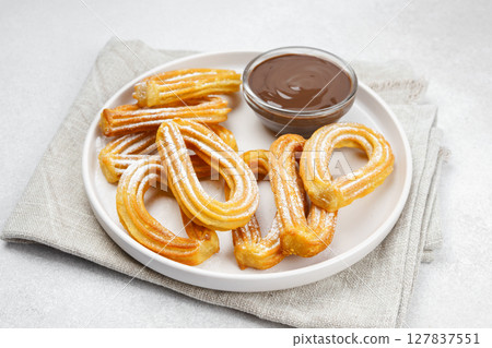Traditional spanish dessert churros, fried dough pastry and chocolate macro, close up 127837551