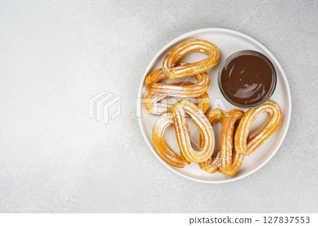 Traditional spanish dessert churros, fried dough pastry and chocolate sause on white background 127837553