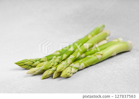 Pile of fresh raw green asparagus or sparrowgrass stems on light textured background 127837563