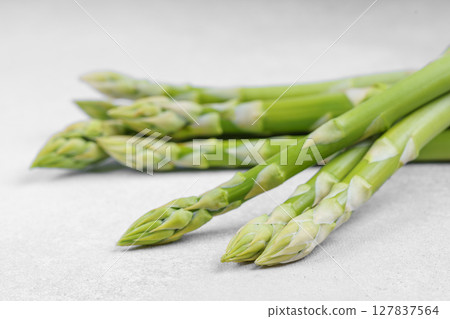 Pile of fresh raw green asparagus or sparrowgrass stems on light textured background 127837564