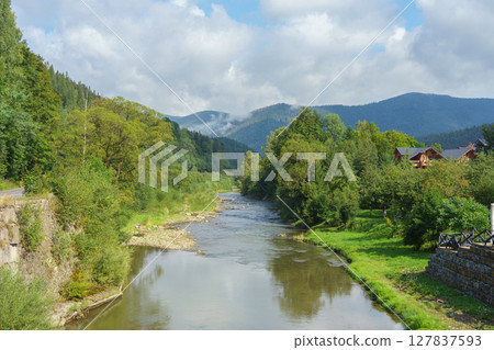 Scenic mountain river landscape with forest and cloudy sky in the Ukrainian Carpathians 127837593