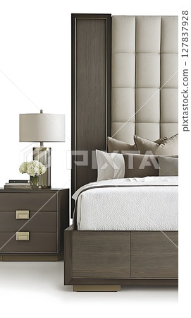 A bed with a white comforter and pillows, a nightstand with a lamp 127837928