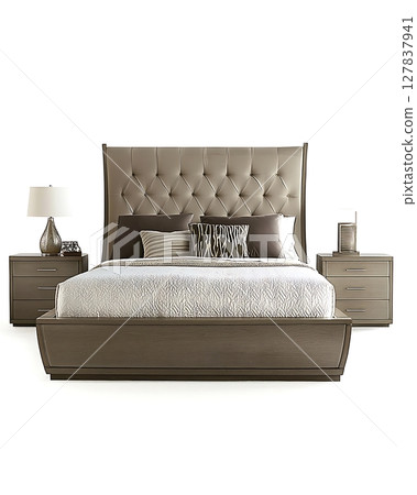 A bed with a white comforter and pillows, and a nightstand with a lamp 127837941